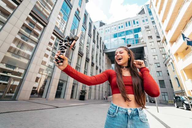 Joven bloguera con transmisión de teléfonos inteligentes en la calle