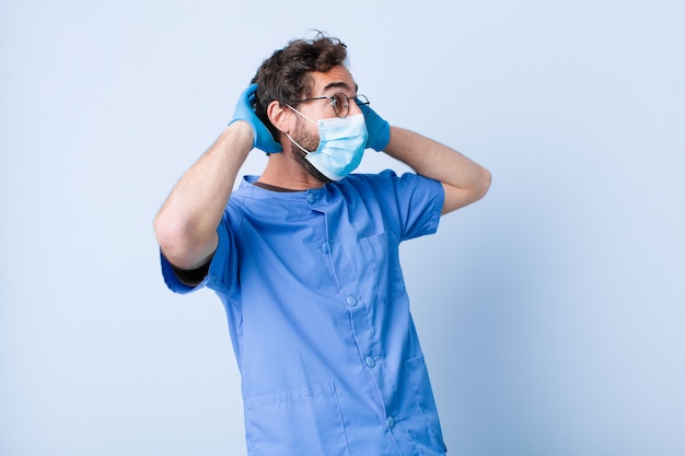 Joven con la boca abierta, horrorizado y conmocionado por un terrible error, levantando las manos a la cabeza. concepto de coronavirus