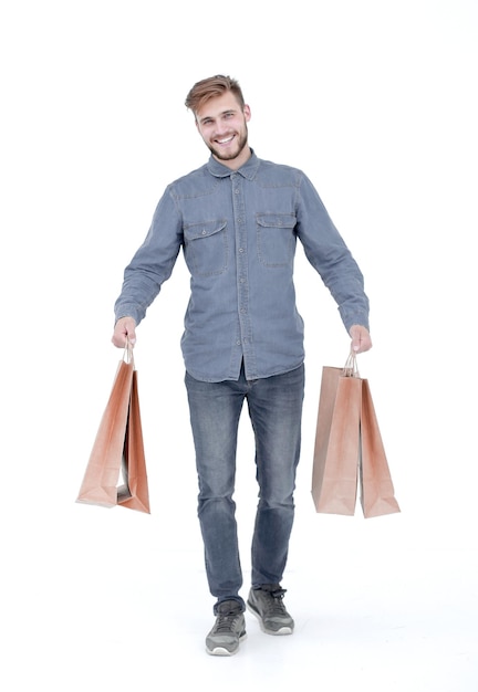 Un joven con bolsas de papel marrón en las manos.