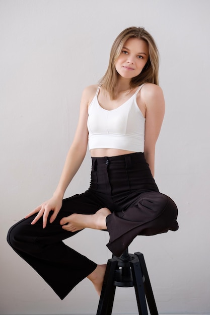 joven bonita de cabello marrón con maquillaje ligero diurno y cabello bien cuidado en una camiseta blanca