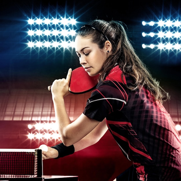 Joven y bonita chica deportiva jugando al tenis de mesa