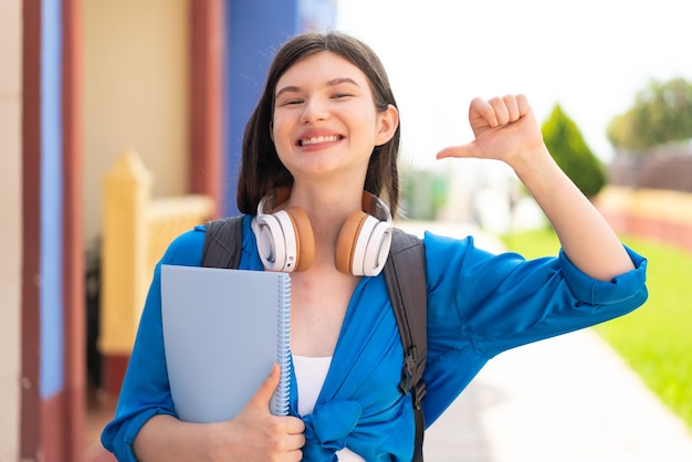 Foto joven y bonita estudiante ucraniana al aire libre orgullosa y satisfecha de sí misma