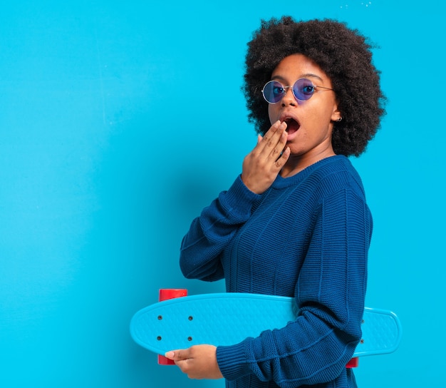 Joven bonita a mujer afro con una patineta