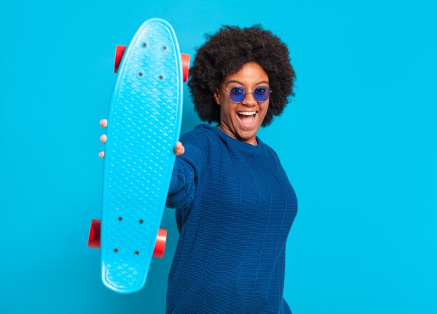 Joven bonita a mujer afro con una patineta