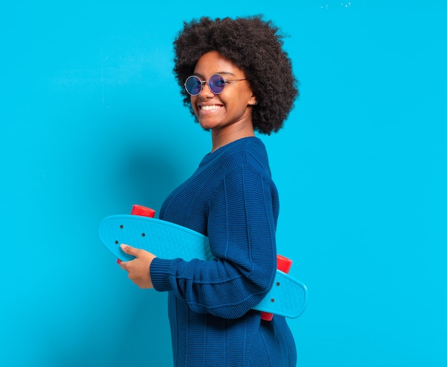 Joven bonita a mujer afro con una patineta