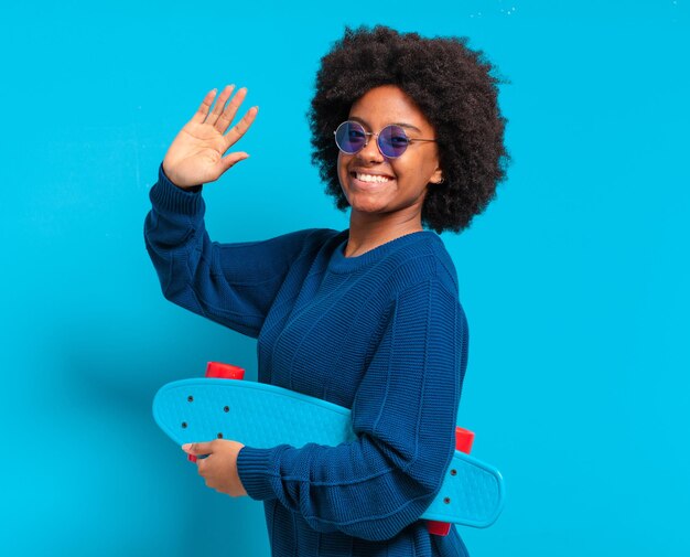 Joven bonita a mujer afro con una patineta