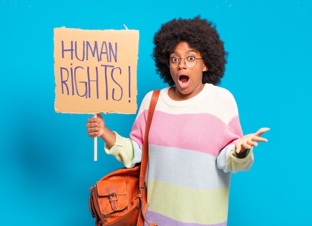 Joven bonita a mujer afro protestando con pancarta de derechos humanos