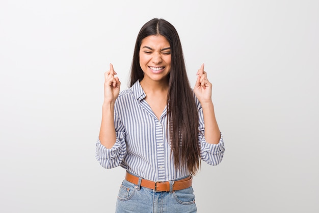 Joven bonita mujer árabe cruzando los dedos para tener suerte