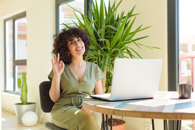 Foto joven bonita a mujer árabe con un ordenador portátil sobre una mesa