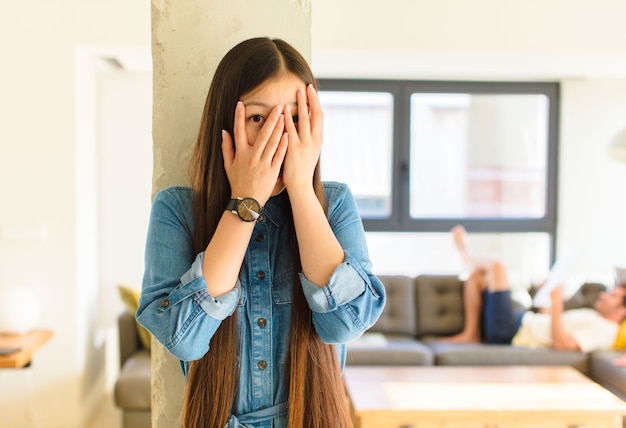 Joven bonita a mujer asiática que se siente asustada o avergonzada