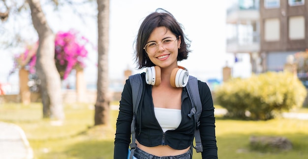 Joven y bonita mujer búlgara al aire libre sosteniendo un cuaderno con expresión feliz