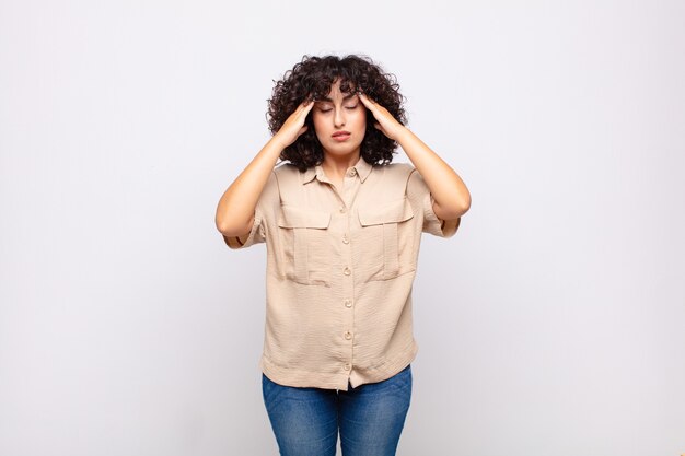 Joven bonita a mujer con cabello rizado y camisa beige