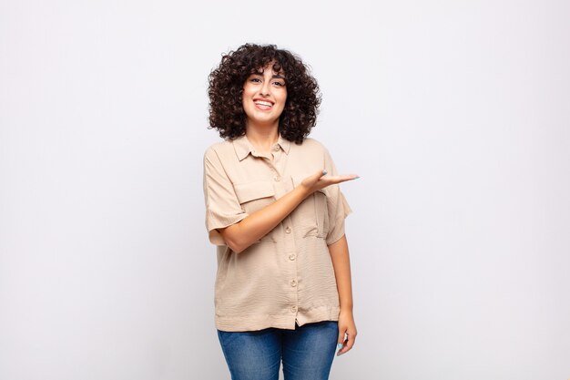 Joven bonita a mujer con cabello rizado y camisa beige