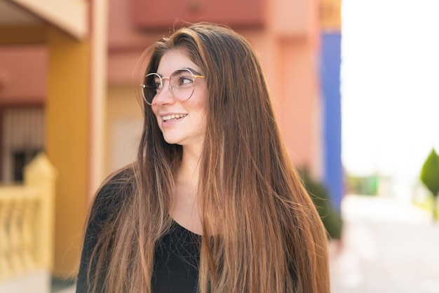 Joven y bonita mujer caucásica con gafas con expresión feliz