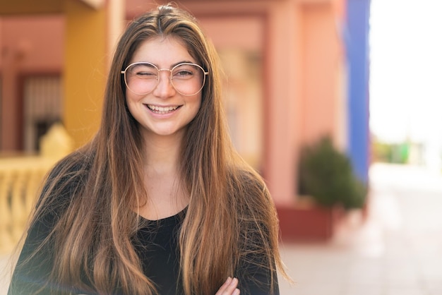 Joven y bonita mujer caucásica con gafas y expresión feliz