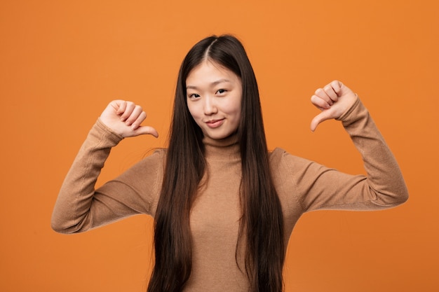 Joven y bonita mujer china se siente orgullosa y segura de sí misma.