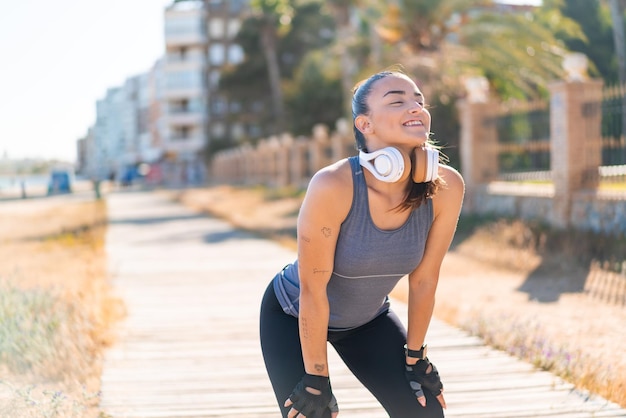 Joven bonita mujer deportiva con ropa deportiva con expresión feliz