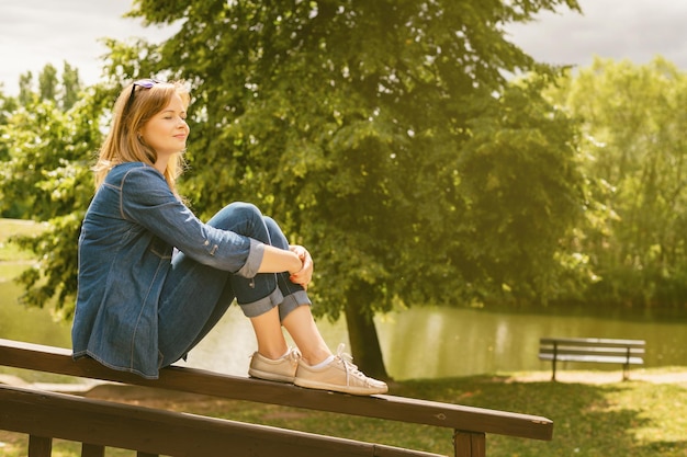 Una joven y bonita mujer se descansa en un parque al aire libre relajándose