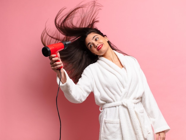 joven bonita mujer hispana. expresión feliz y sorprendida. concepto de secador de pelo