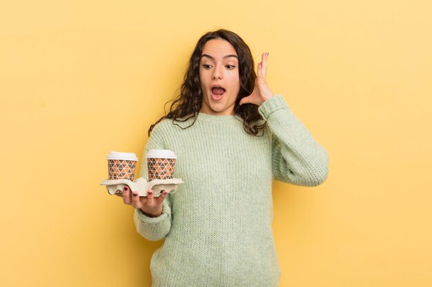 Joven bonita mujer hispana gritando con las manos en el aire para llevar el concepto de café