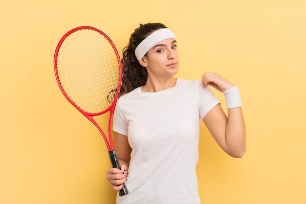 Joven bonita mujer hispana que parece arrogante, exitosa, positiva y orgullosa concepto de tenis