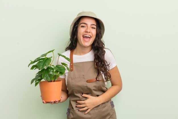 Joven y bonita mujer hispana riéndose a carcajadas de alguna broma hilarante concepto de agricultor o jardinero