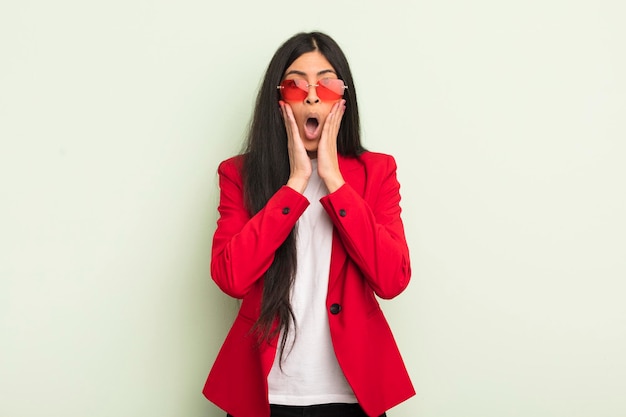 Joven bonita mujer hispana sintiéndose conmocionada y asustada concepto de mujer de negocios