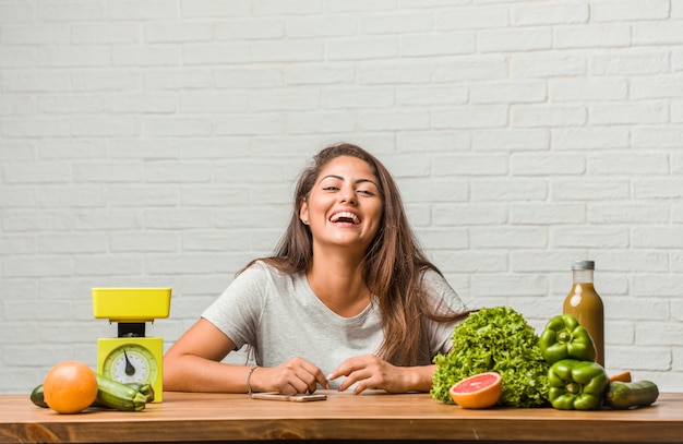 Joven y bonita mujer latina shwoing su comida de dieta, ella se está divirtiendo, disfrutando de su estilo de vida.