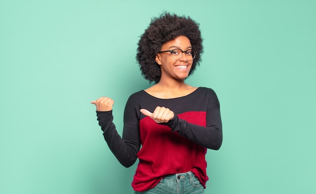 Joven bonita a mujer negra apuntando al espacio de la copia