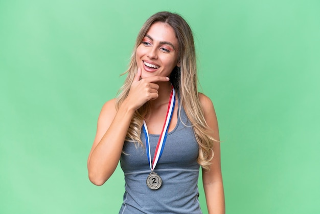 Joven bonita mujer uruguaya deportiva con medallas sobre un fondo aislado mirando hacia un lado