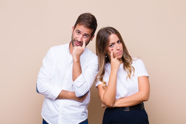 Joven bonita pareja sobre pared beige