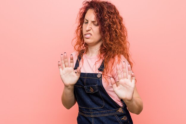 Foto joven bonita pelirroja pelirroja vestida con un pantalón vaquero que rechaza a alguien