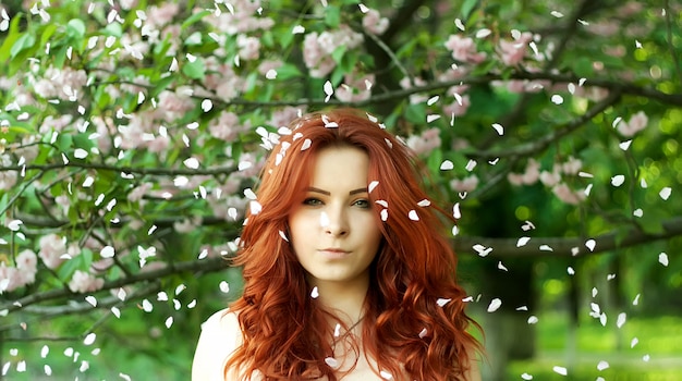 Joven bonita posando bajo un árbol de sakura