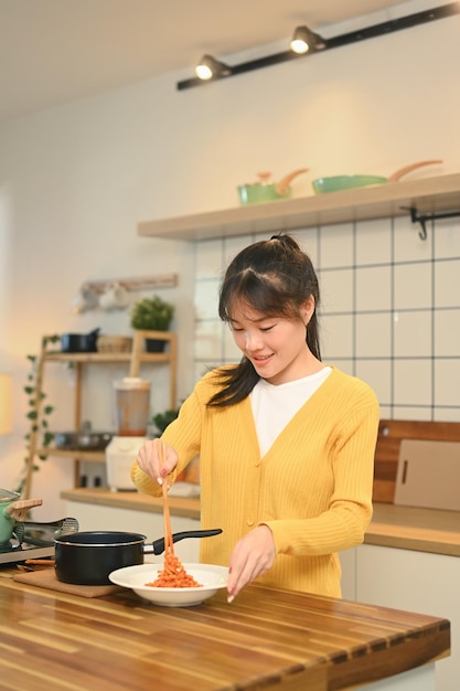 Una joven bonita preparando una deliciosa comida en una cocina moderna