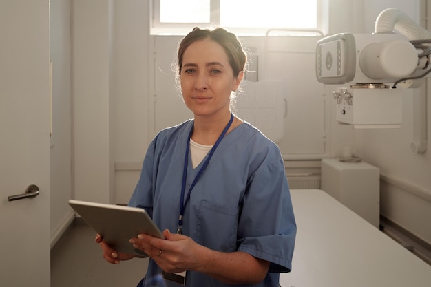 Una joven y bonita radióloga con tableta trabajando en el hospital