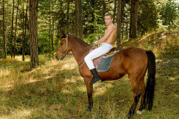 Joven en el bosque a caballo