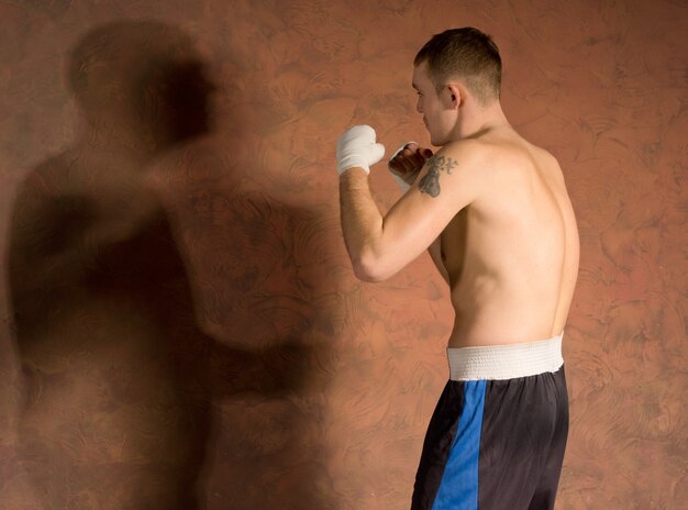 Joven boxeador en entrenamiento físico trabajando