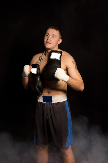 Joven boxeador en forma muscular preparándose para una pelea