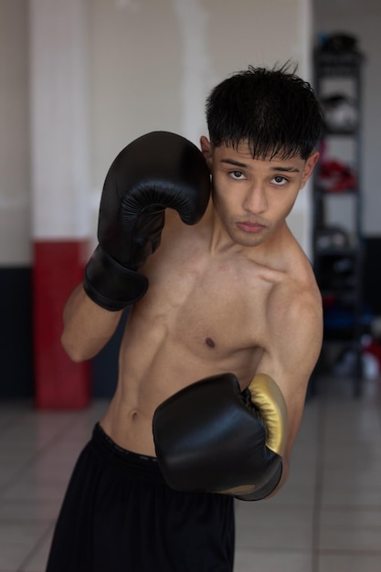 Joven boxeador mexicano posando y mirando a la cámara en posición de pelea