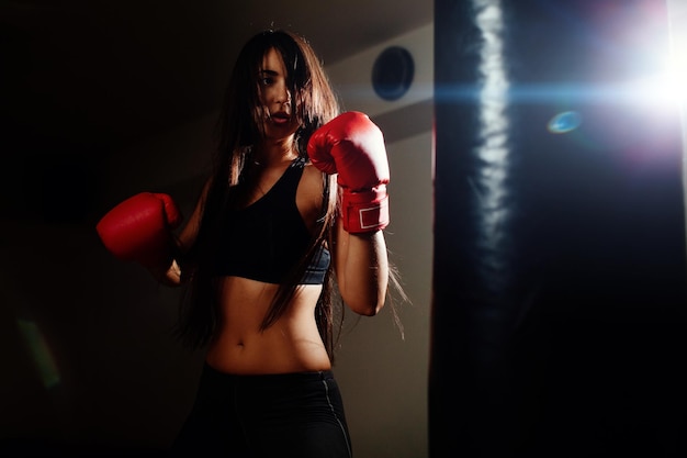 Foto joven boxeadora practicando en el gimnasio