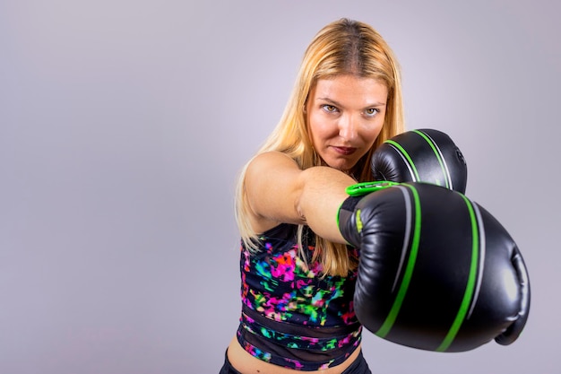 Foto joven boxeadora rubia ejerciendo sus puños