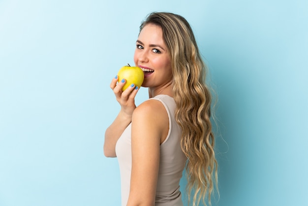 Joven brasileña aislada comiendo una manzana