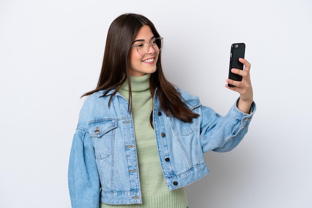 Joven brasileña aislada de fondo blanco haciendo un selfie