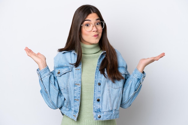 Foto joven brasileña aislada de fondo blanco que tiene dudas mientras levanta las manos