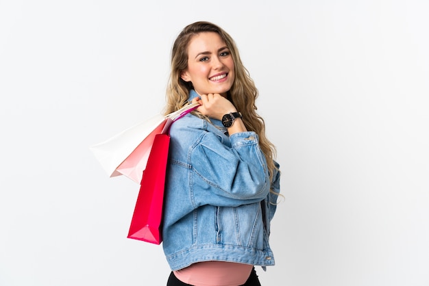 Joven brasileña aislada sosteniendo bolsas de compras y sonriendo