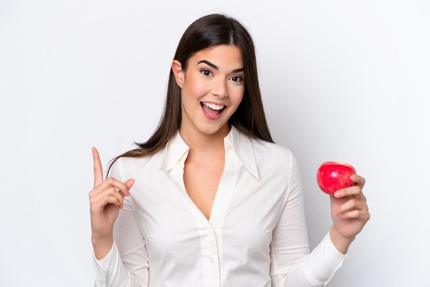 Joven brasileña con una manzana aislada de fondo blanco señalando una gran idea