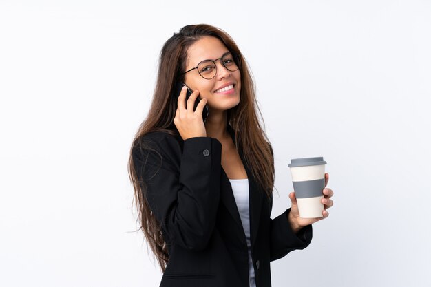 Joven brasileña de negocios con móvil y sosteniendo café para llevar