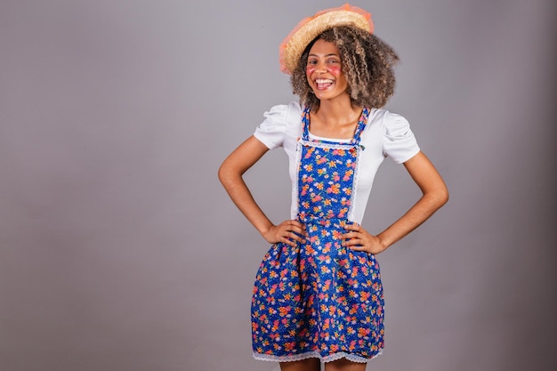 Joven brasileña negra con ropa de campo vestida para Festa Junina Saint John's festival Manos en las caderas