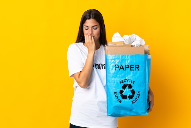 Joven brasileña sosteniendo una bolsa de reciclaje llena de papel para reciclar aislado