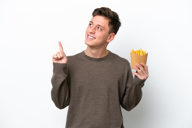Joven brasileño sosteniendo patatas fritas aisladas de fondo blanco señalando una gran idea